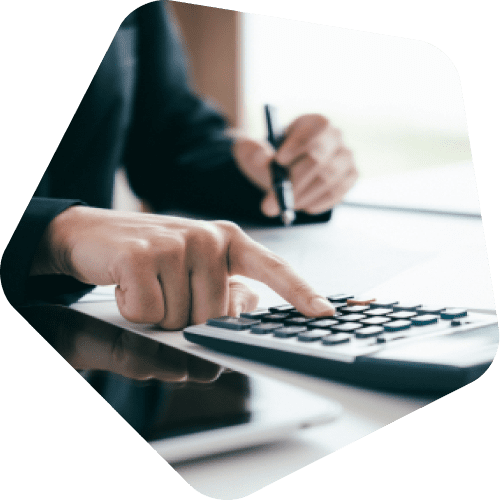 Person using a calculator while writing notes, focusing on their hands.