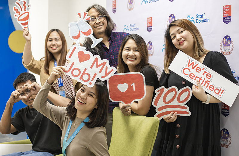 Group of people holding positive message signs in an office.